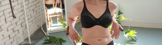 Image of woman sitting in a chair wearing a unlined and supportive bra from Chantelle. 