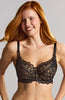 Person in front of neutral background wearing black lace bra with gold hardware.