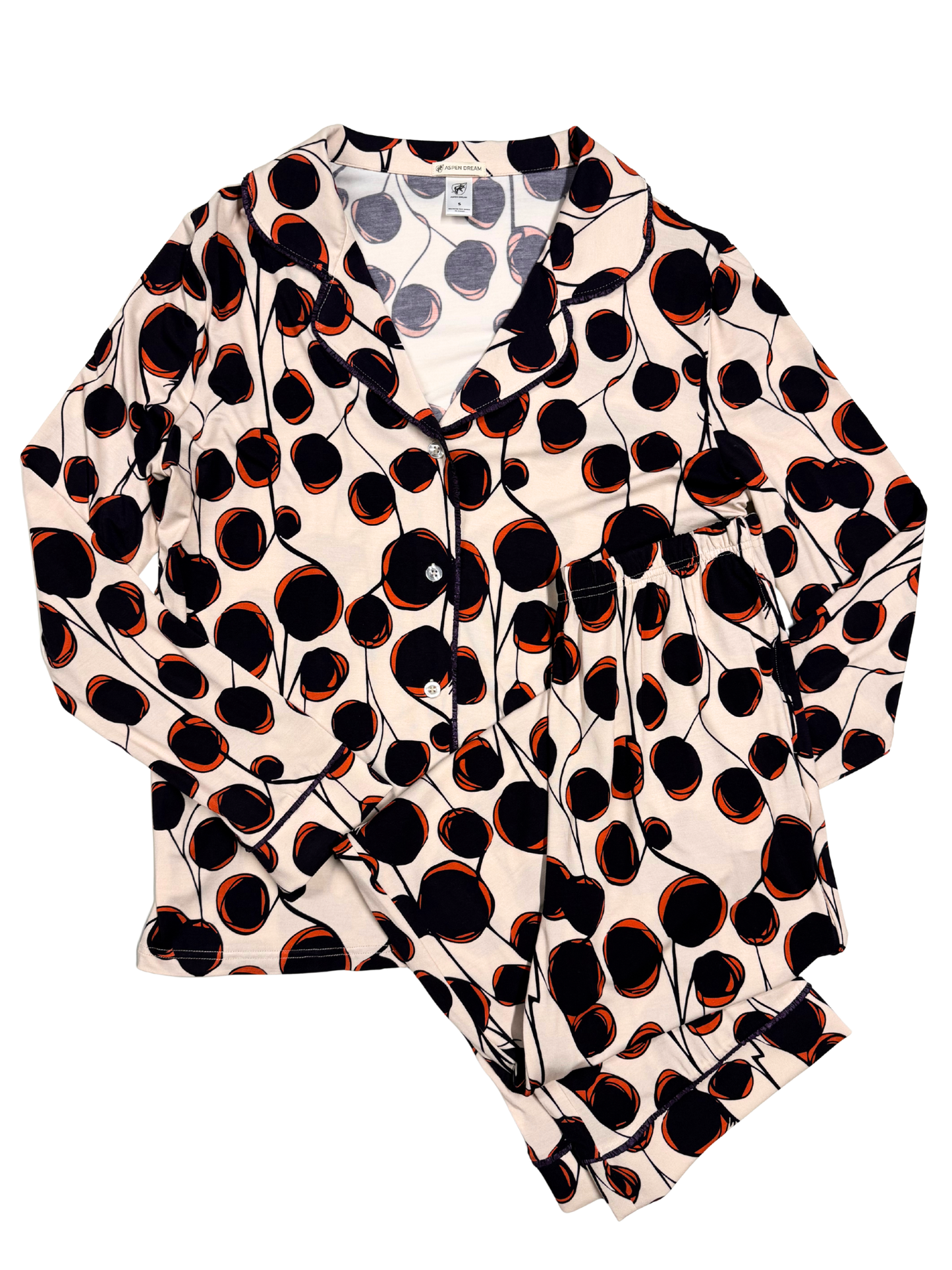 long pajama set, white with black and red abstract spot design, laying flat on a white background.