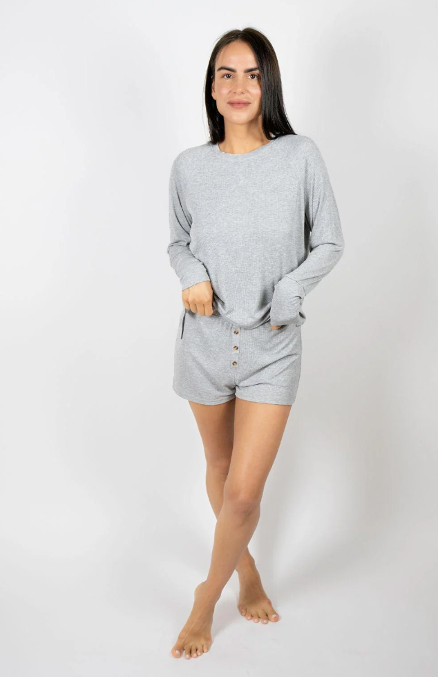 Woman wearing grey pajamas against a white background