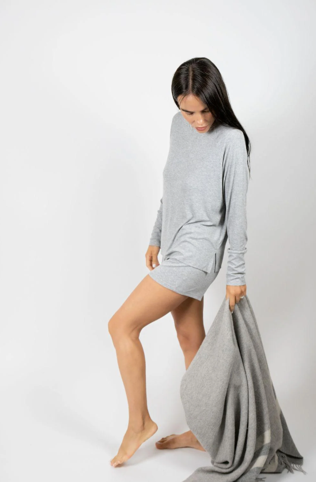 woman wearing grey pajamas against a white background