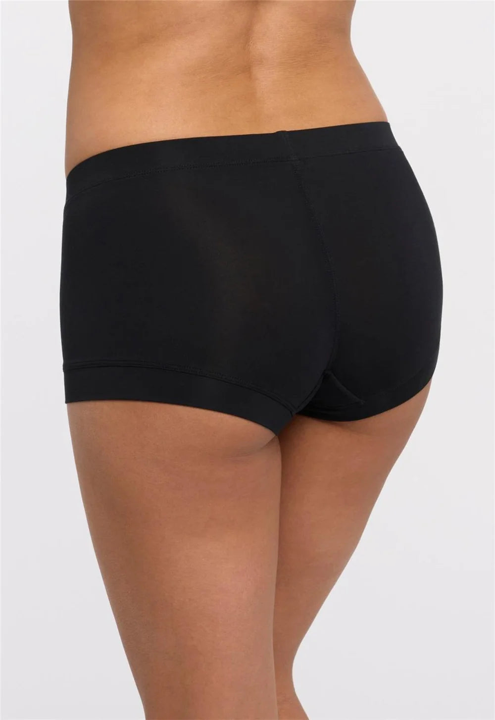 Black boxer-style underwear worn by a person on a white background