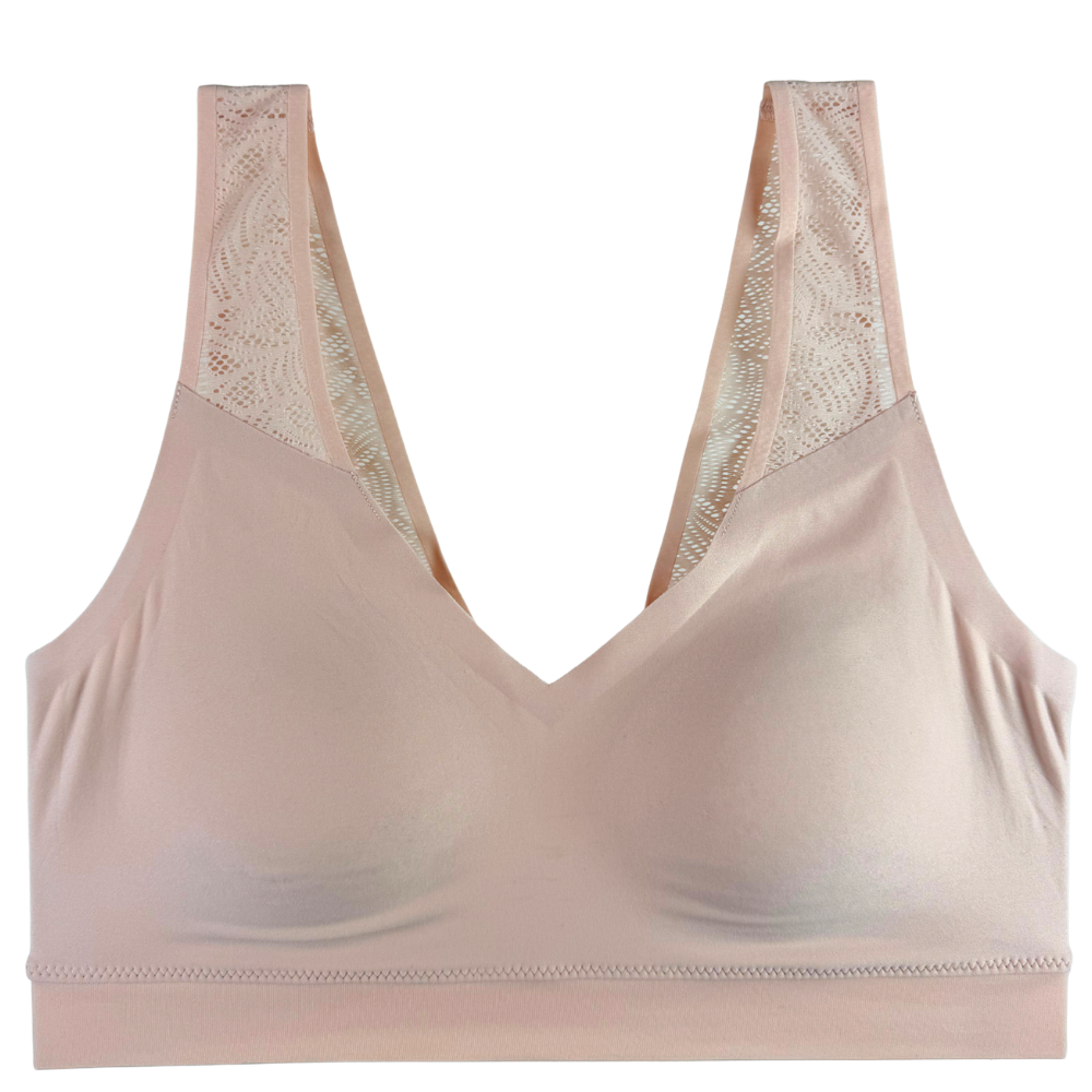 A pale blush pink wireless bra with wide straps and lace detailing at the shoulder, shown against a plain white background.