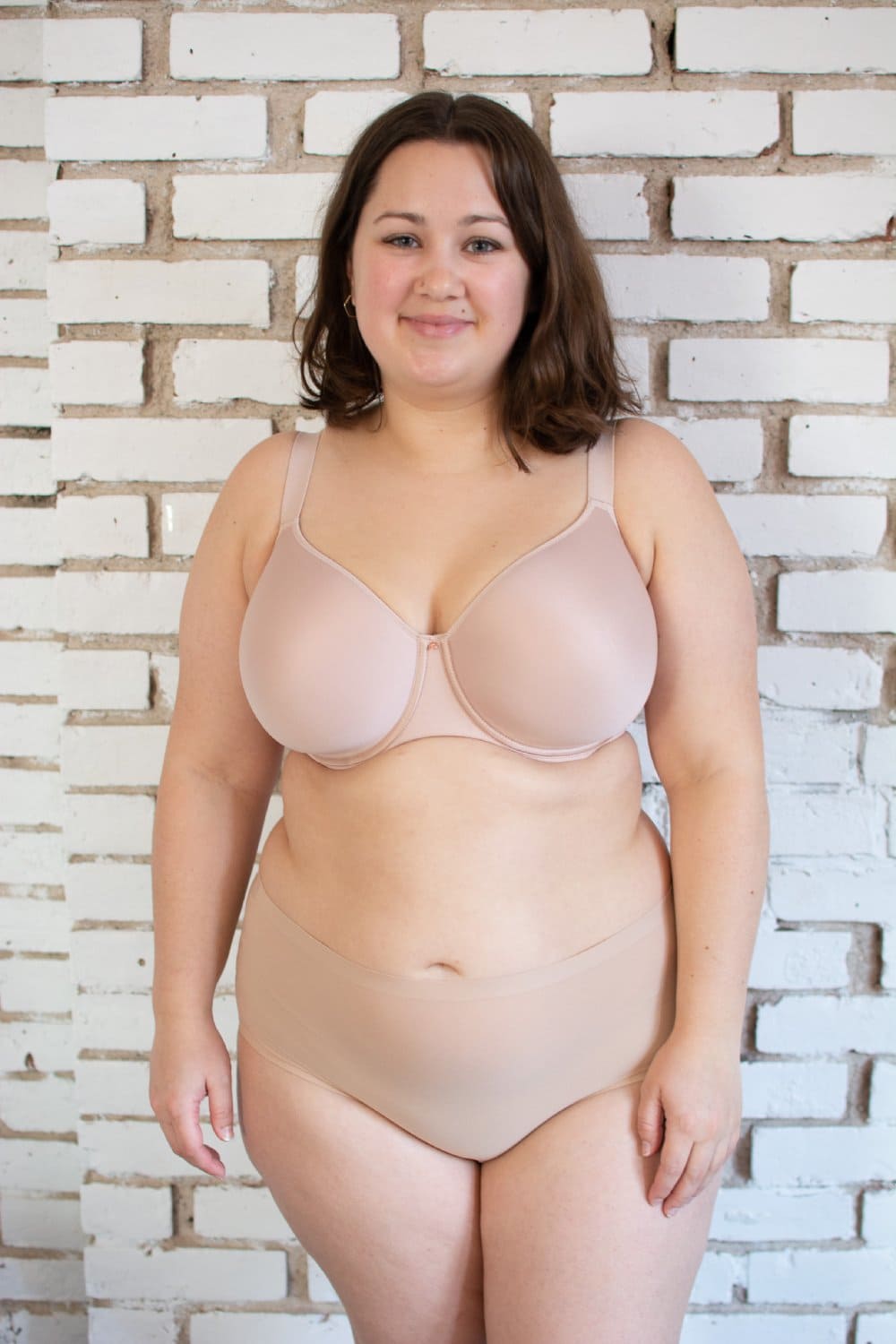 Chantelle Comfort Chic back smoothing T-shirt bra in soft pink, front view on a model, on brick wall background.