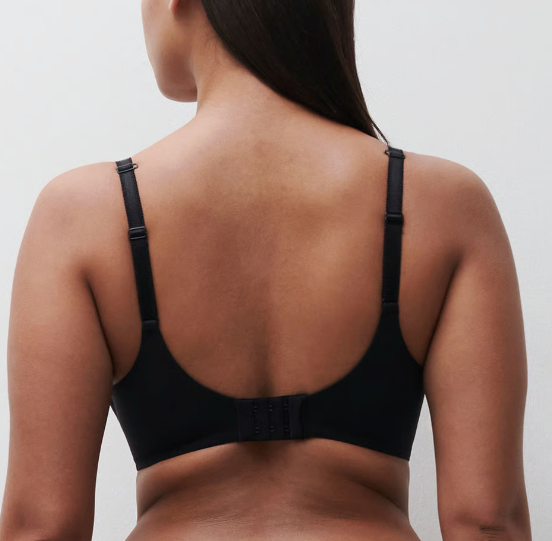 Black bra worn by a person on a plain background