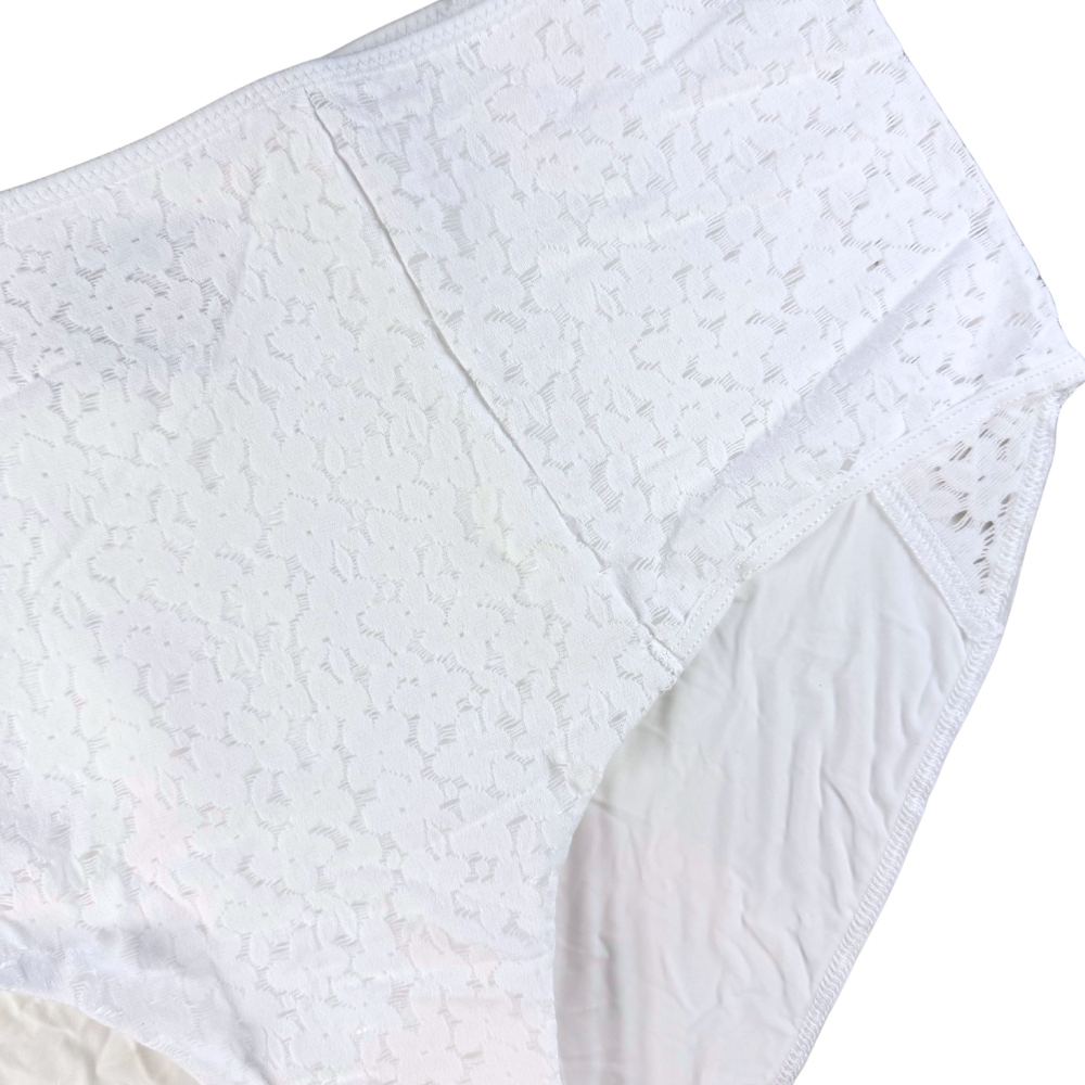 Close-up of a textured white fabric with a subtle pattern on a white background