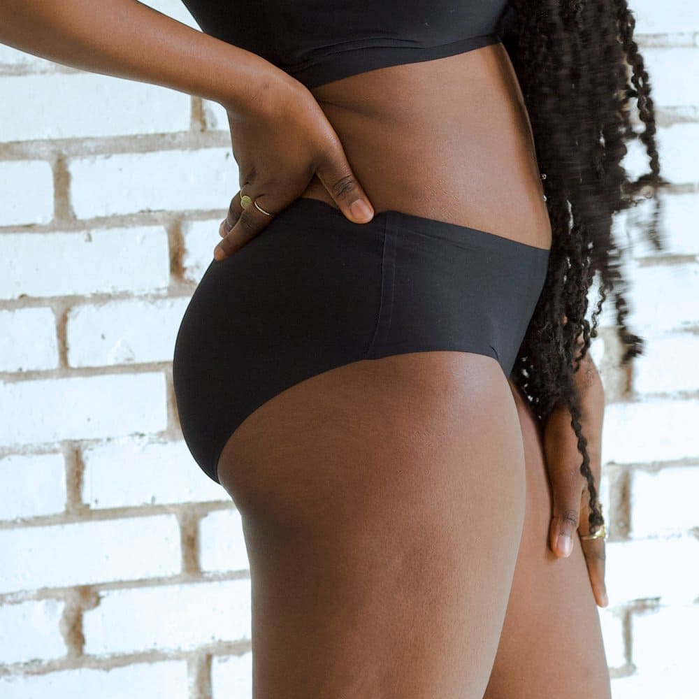 Chantelle soft stretch hipster in black, side view on a model, close-up.