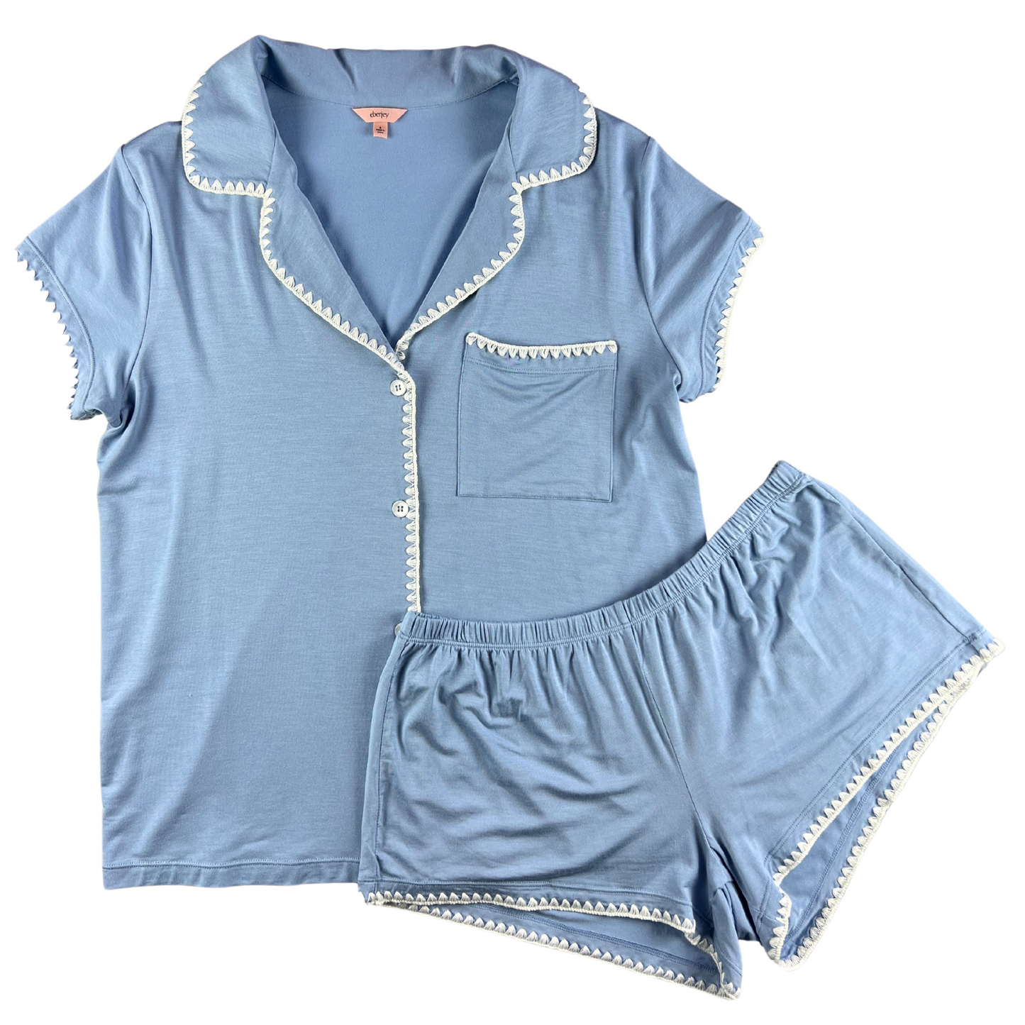 A woman wearing a green short-sleeved pajama set with contrast whipstitching and shorts that hit high on the thigh.