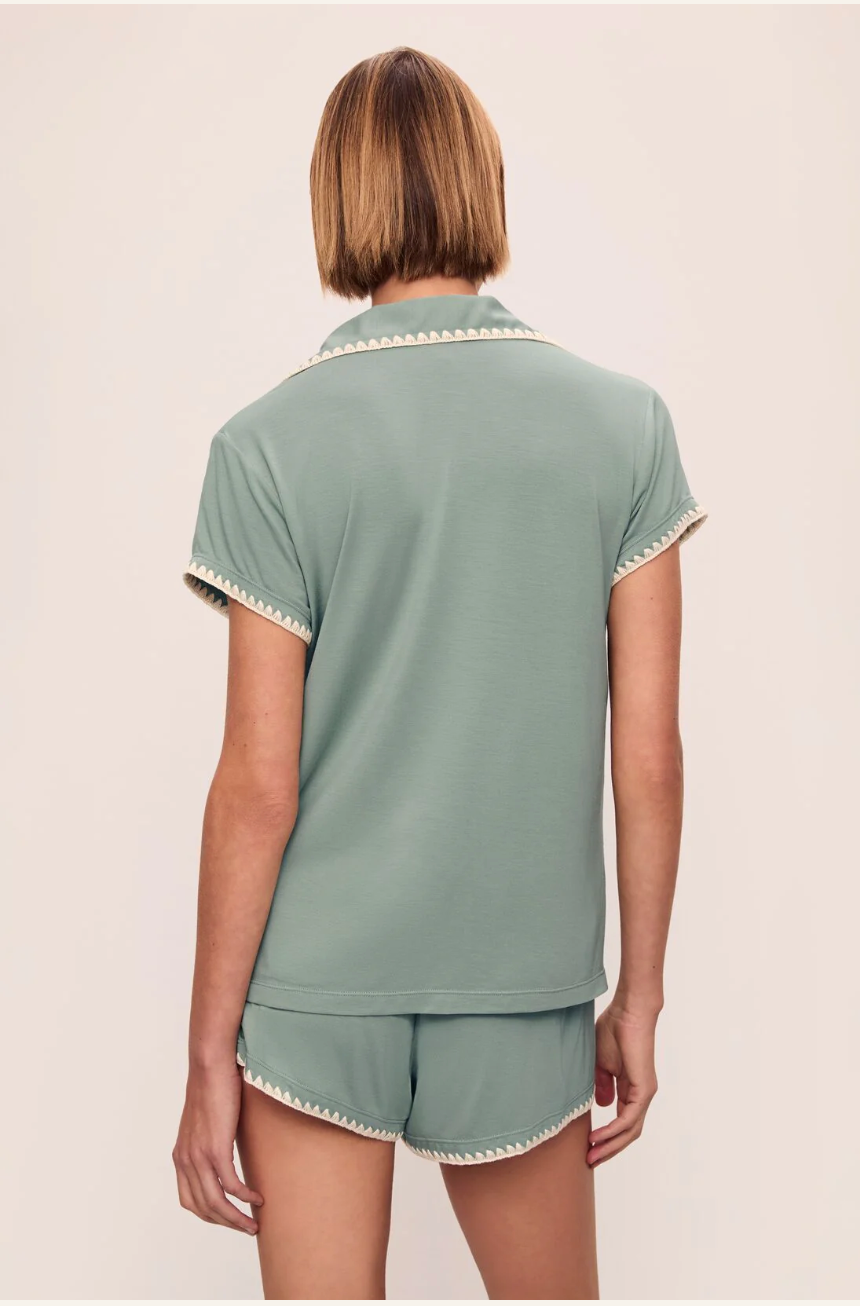 person with their back facing towards us against a white background wearing green pajamas.