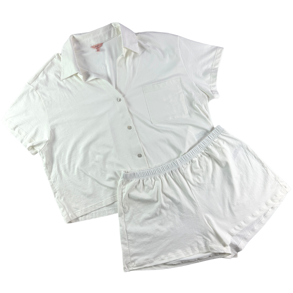 A two-piece white lounge set consisting of a short-sleeve button-up shirt and matching shorts with an elastic waistband, laid flat on a white background.