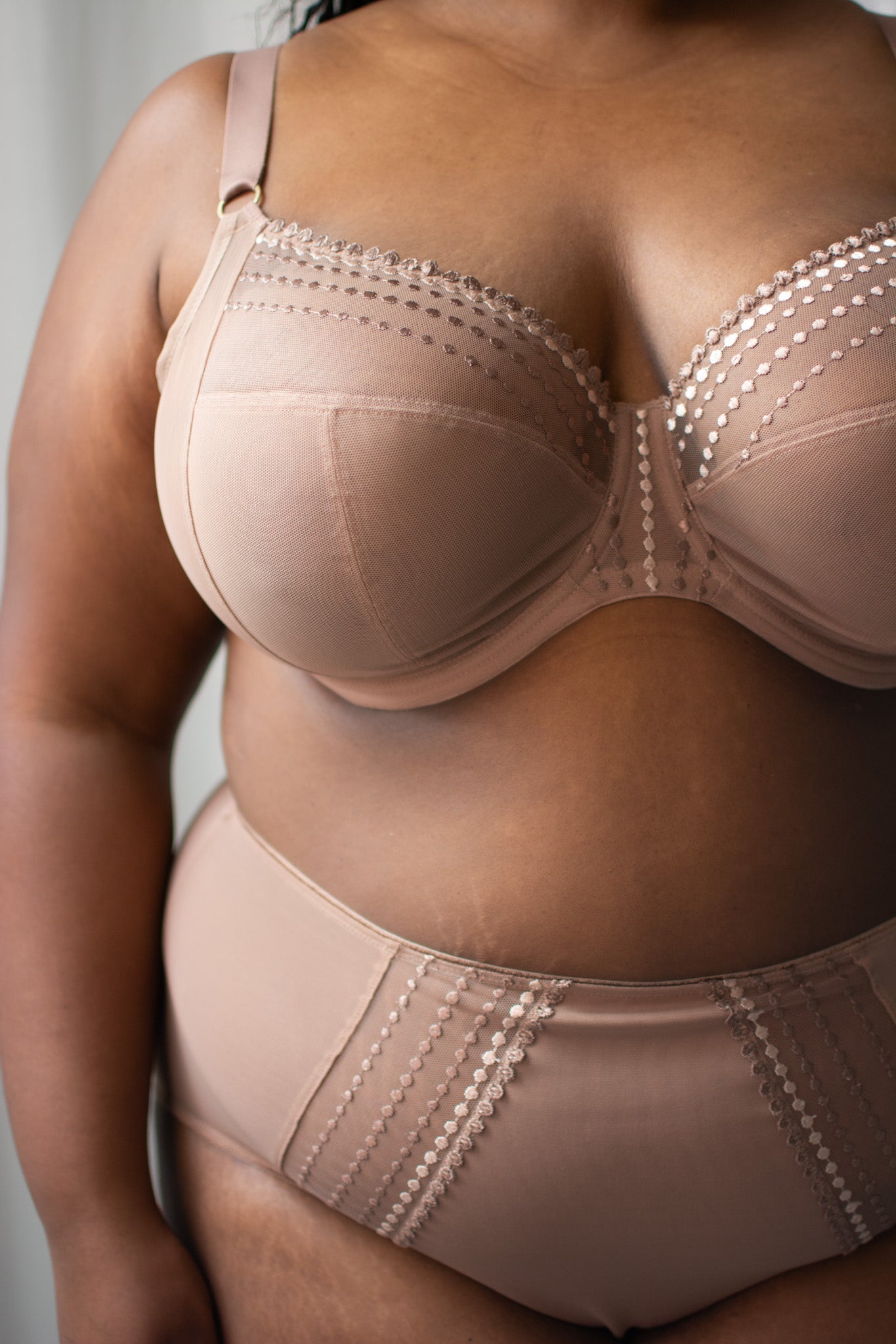 Beige full-coverage bra and shapewear worn by a person against a neutral background