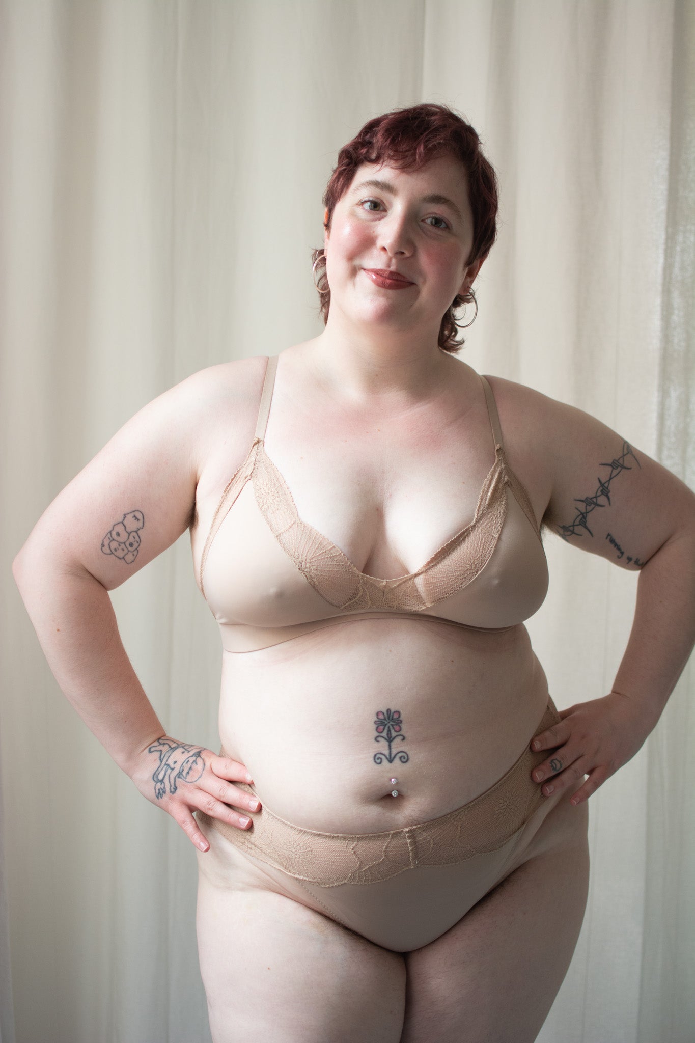Beige lace bralette and underwear on a person with a neutral background.