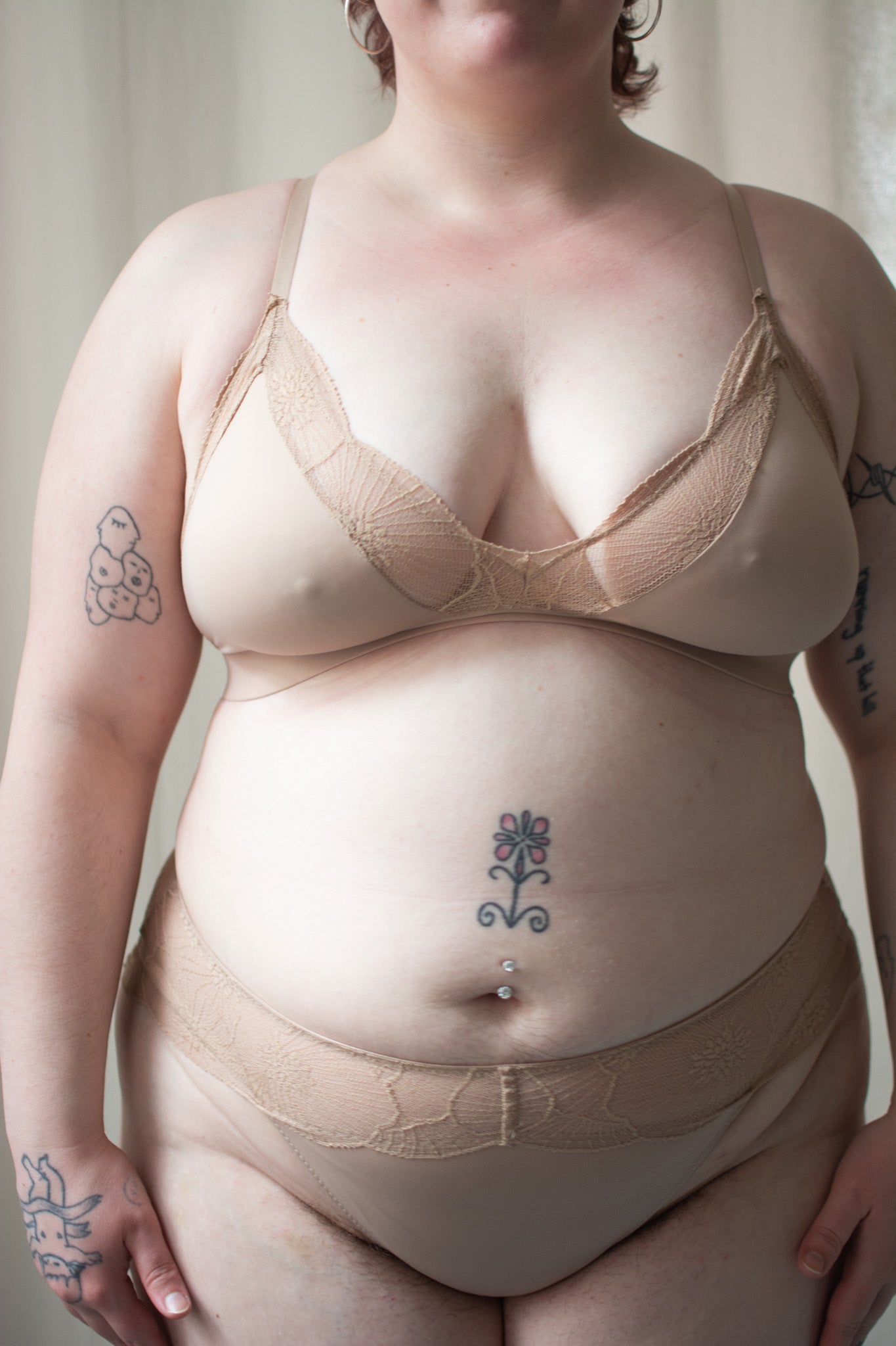 Beige lace bralette and underwear on a person with a neutral background.