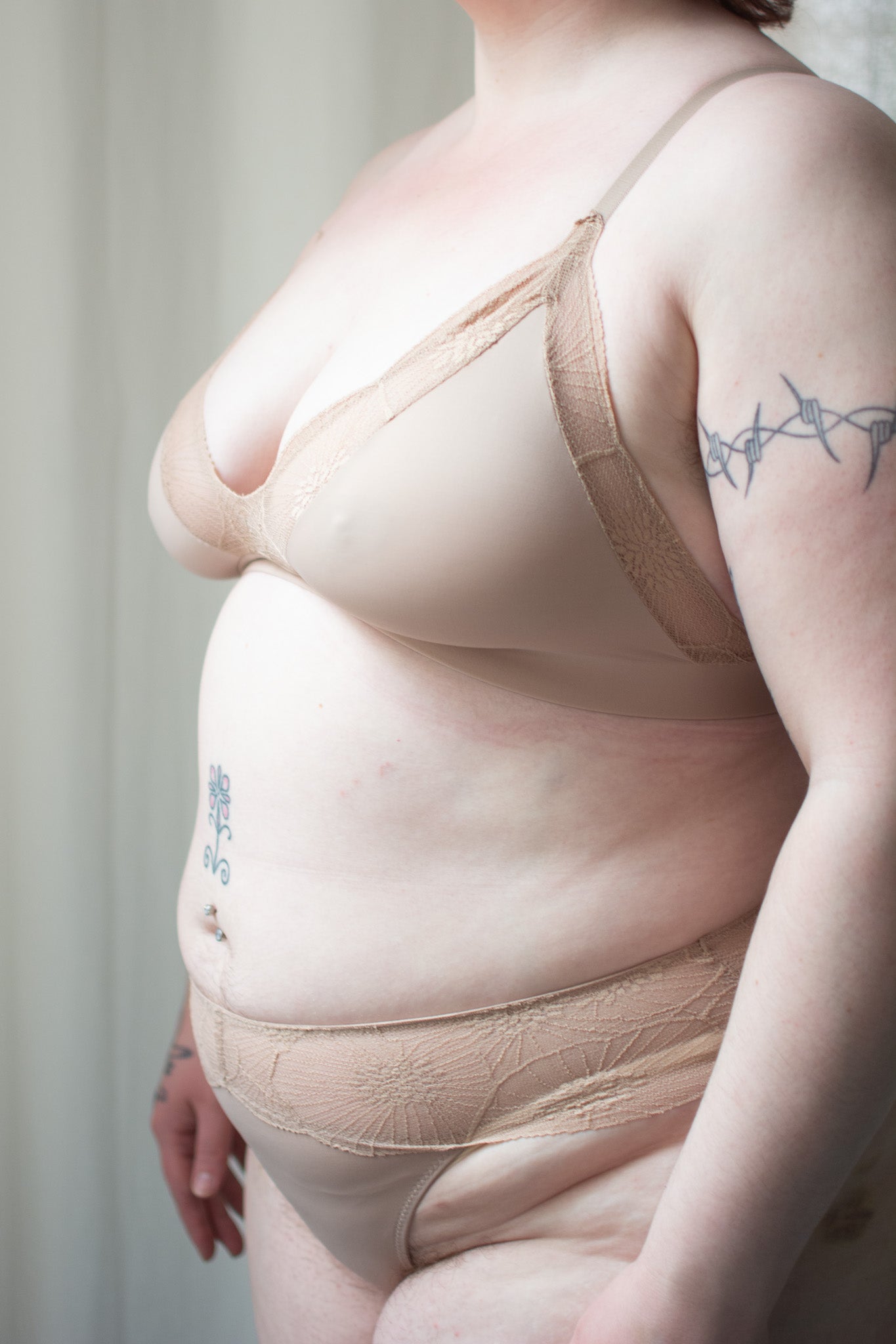 Beige lace bralette and underwear on a person with a neutral background.