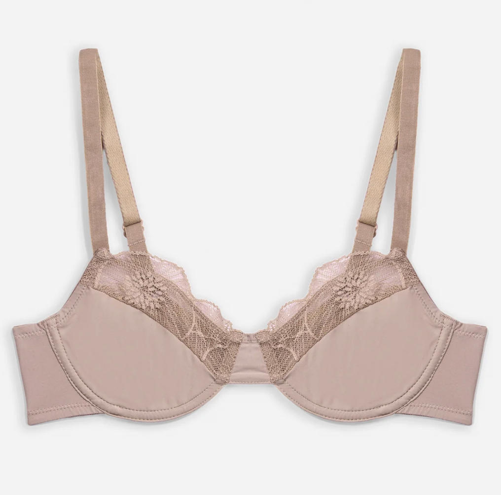 A light beige underwire bra with lace cups and adjustable shoulder straps, shown flat against a light gray background.
