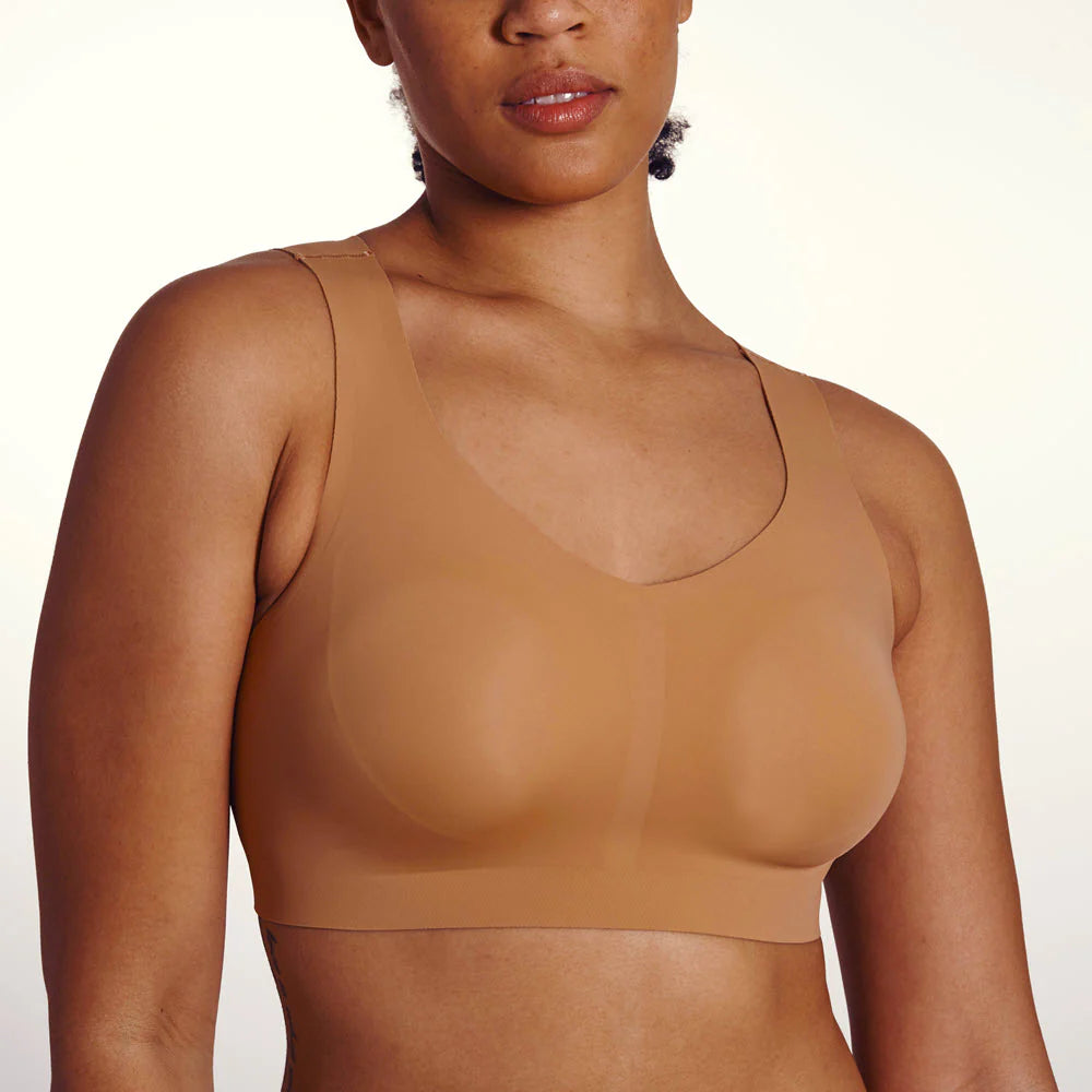 woman wearing beige bra white background