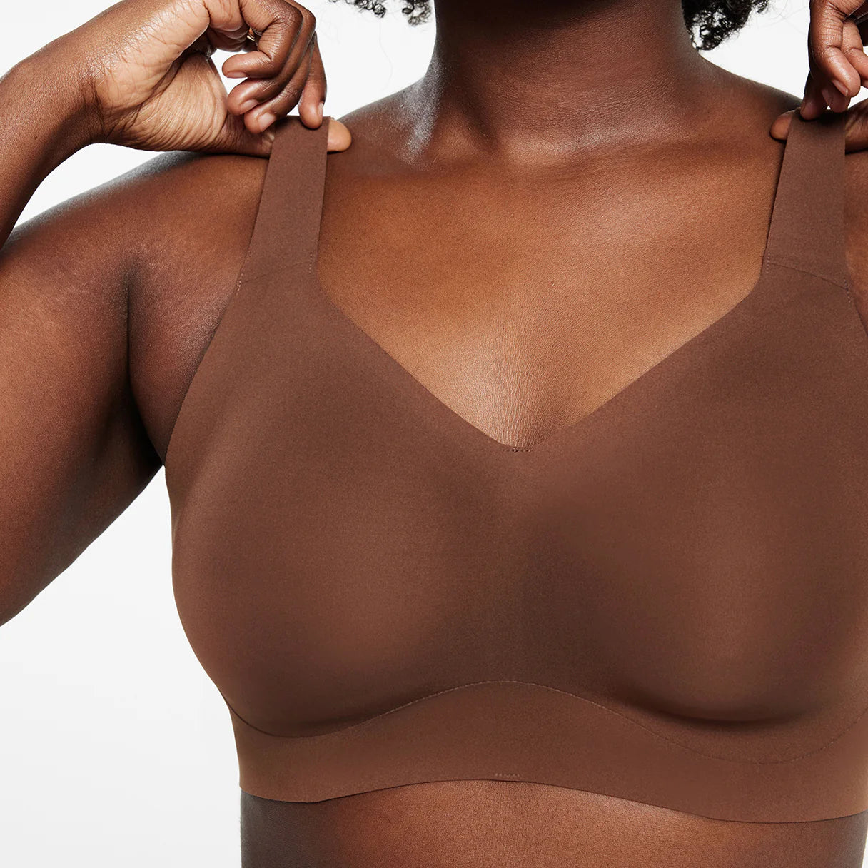 woman wearing brown bra white background