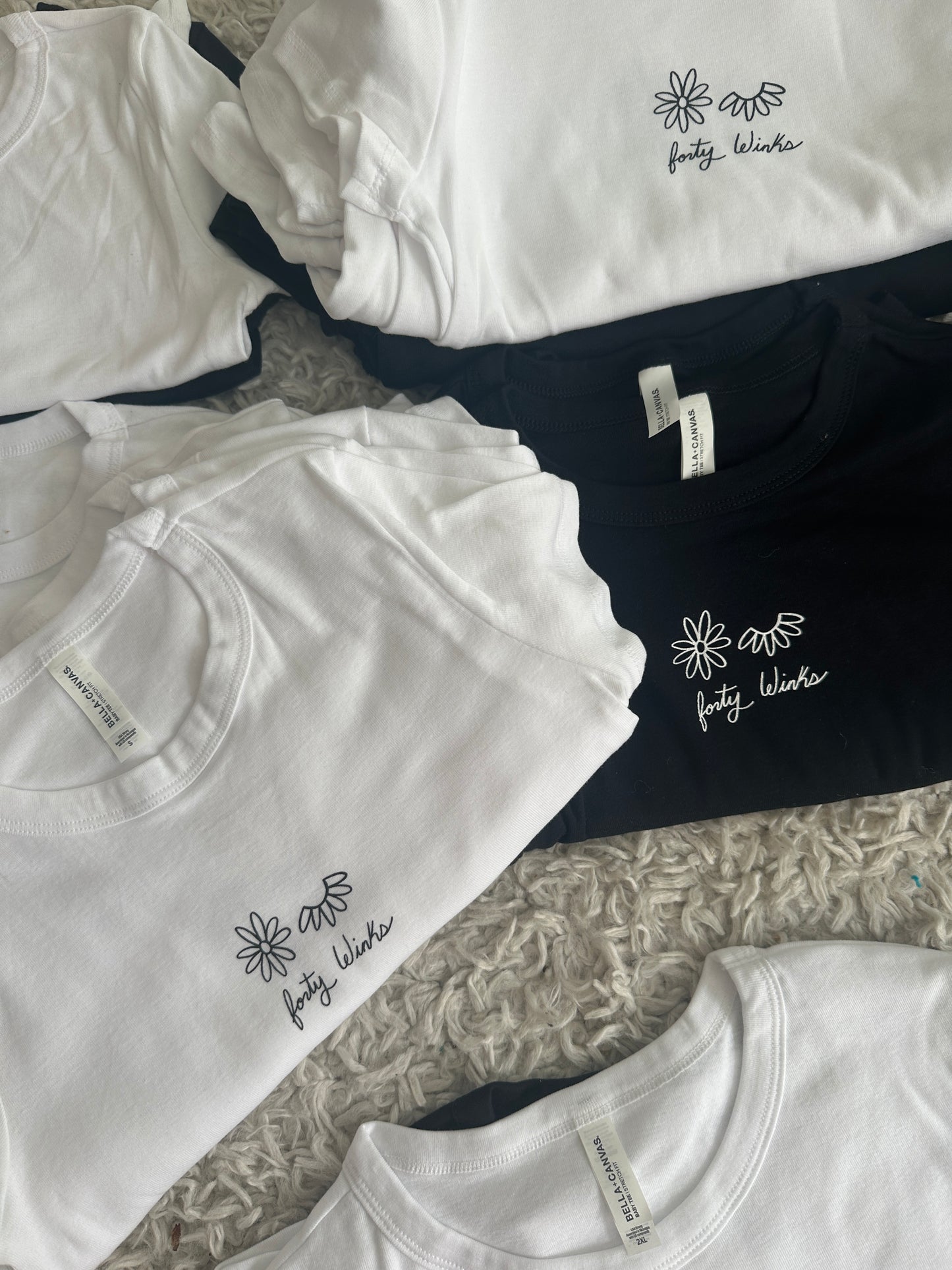 White t-shirts with a logo on a textured surface