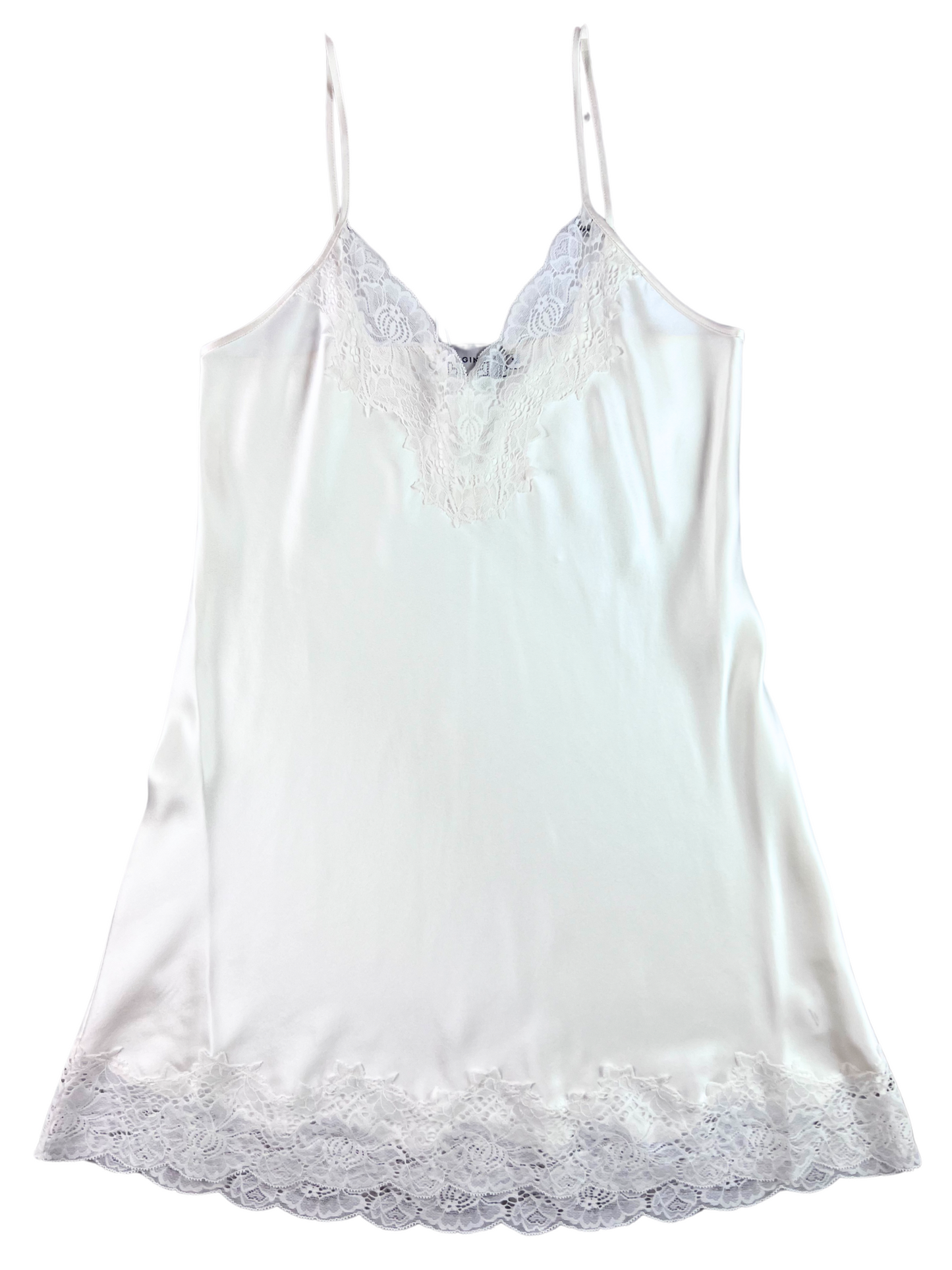A white silk chemise with lace trim at the neckline and a scoop neck.