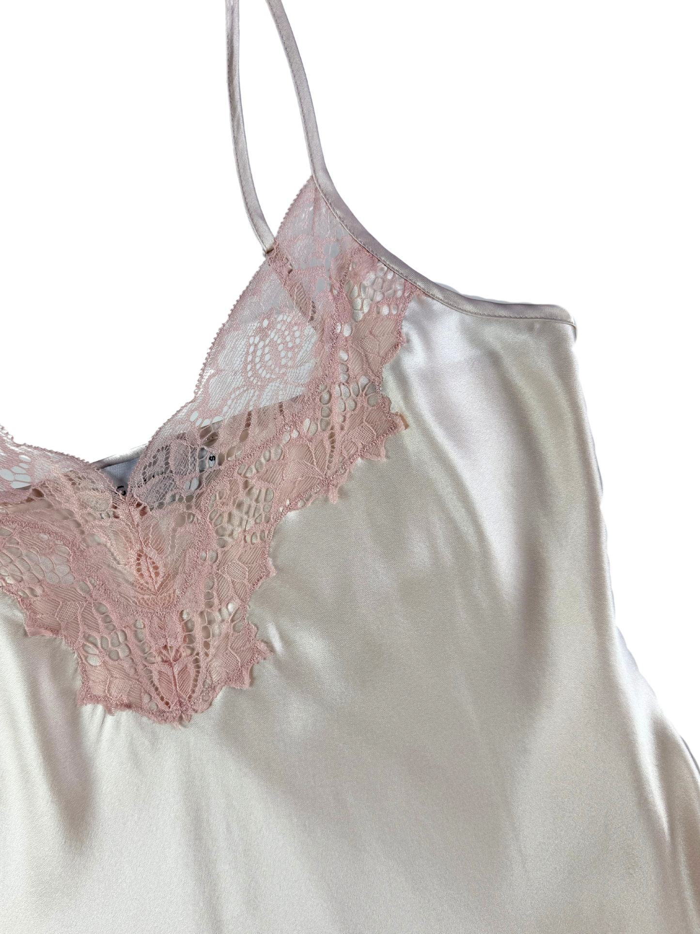 White satin camisole with pink lace trim on a white background