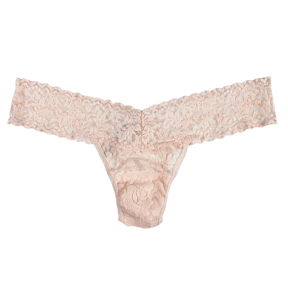 Beige lace thong against a white background.