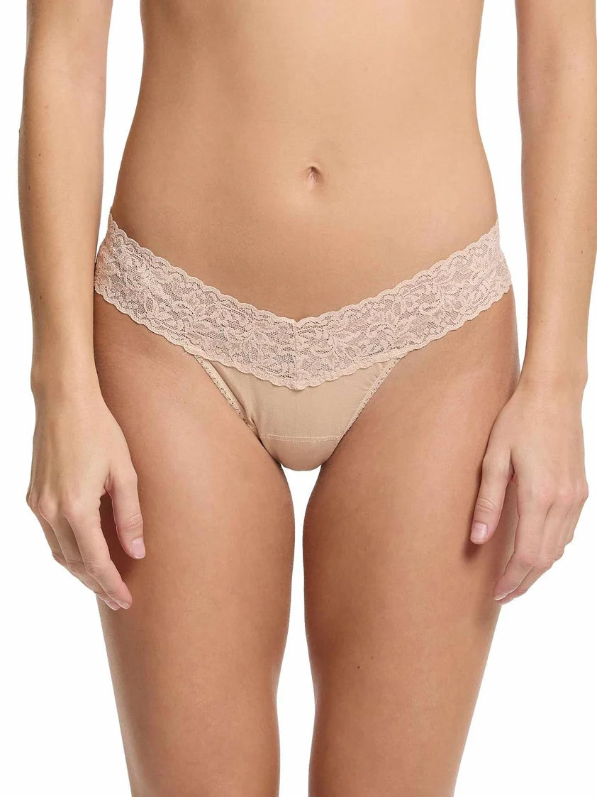model wearing beige lace underwear against a white background