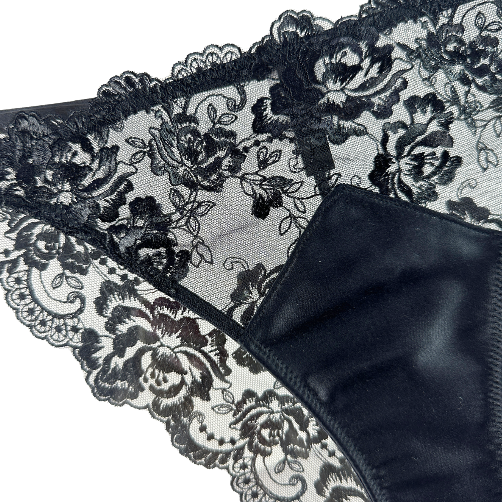 Black lace lingerie with floral patterns on a white background