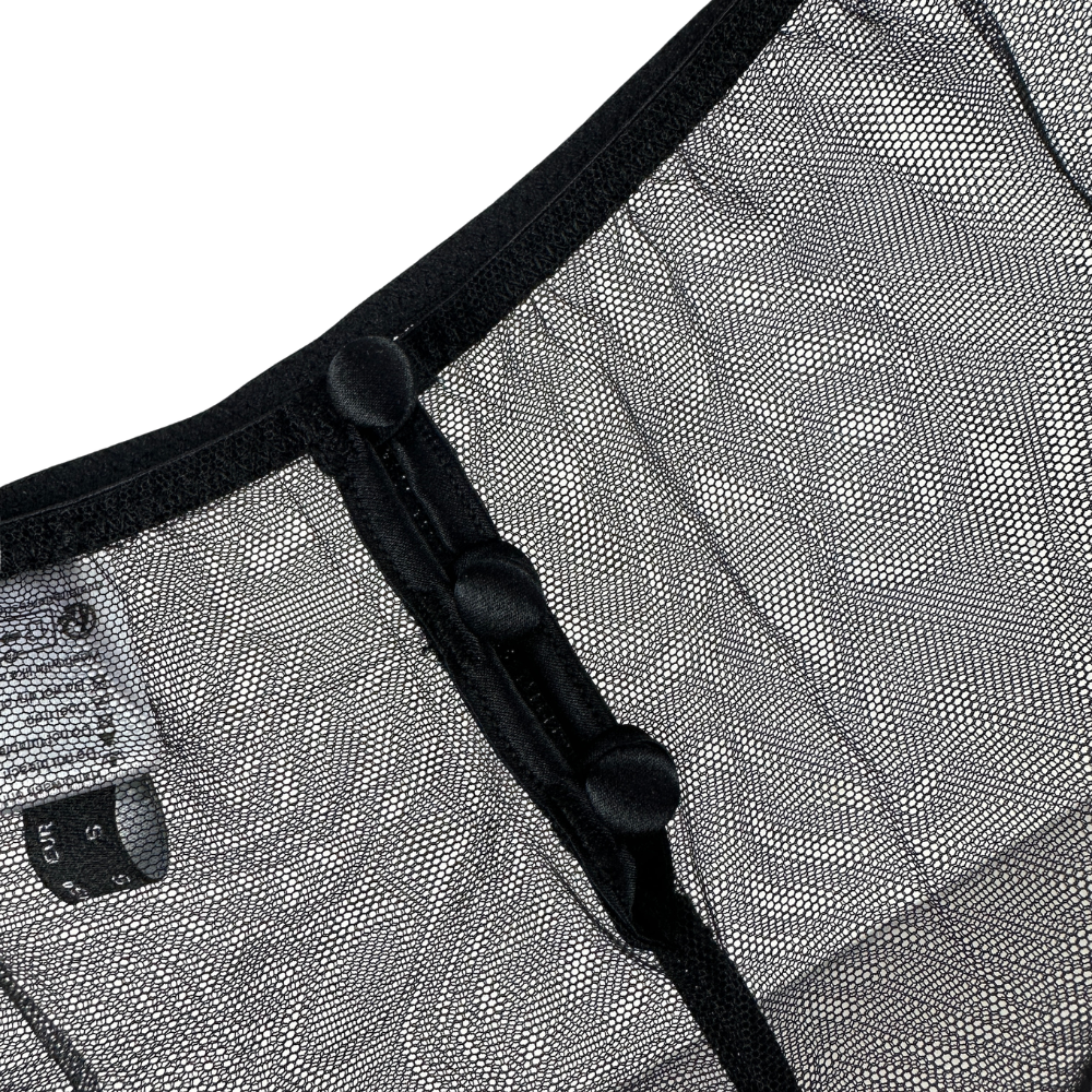 Close-up of a textured fabric with black zipper and buttons on a white background