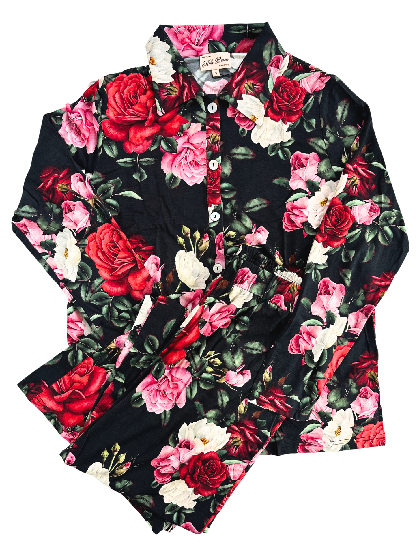 Red, white and pink floral black pajamas with a dollar and button down top, and long pants, folded against a white background.