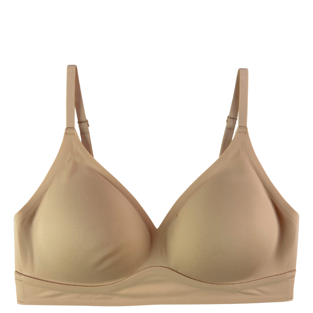 A beige wireless bra with a seamless look, featuring adjustable shoulder straps and a wide underband, shown against a plain white background.