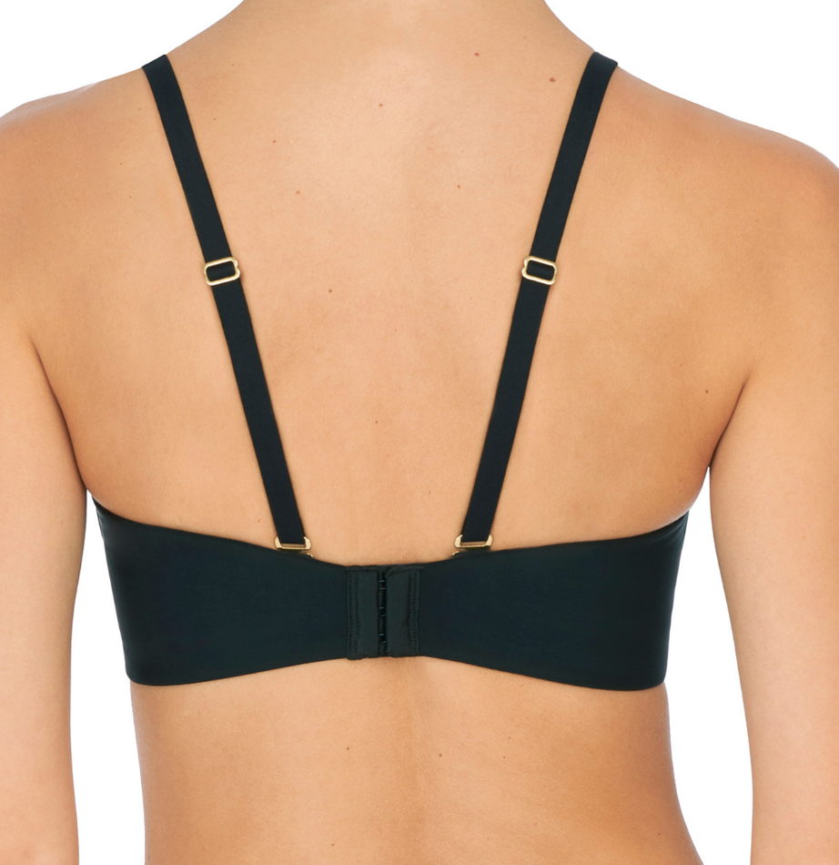Person wearing black bra against a neutral background