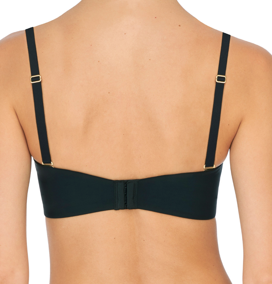 Person wearing black bra against a neutral background