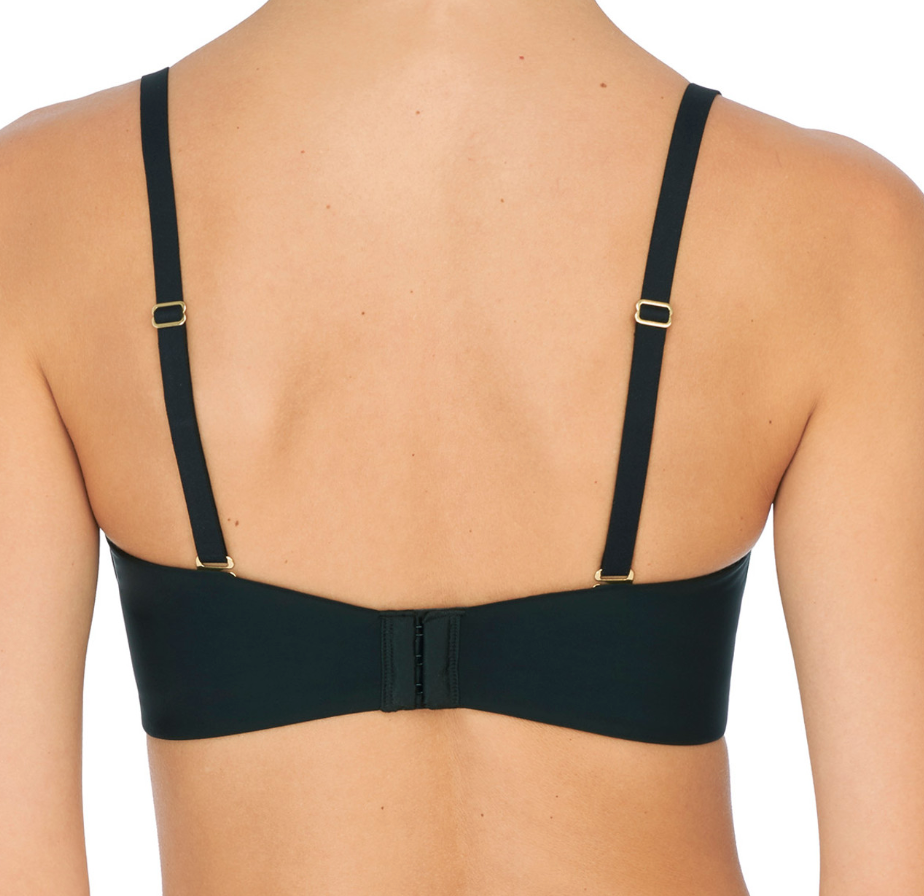 Person wearing black bra against a neutral background