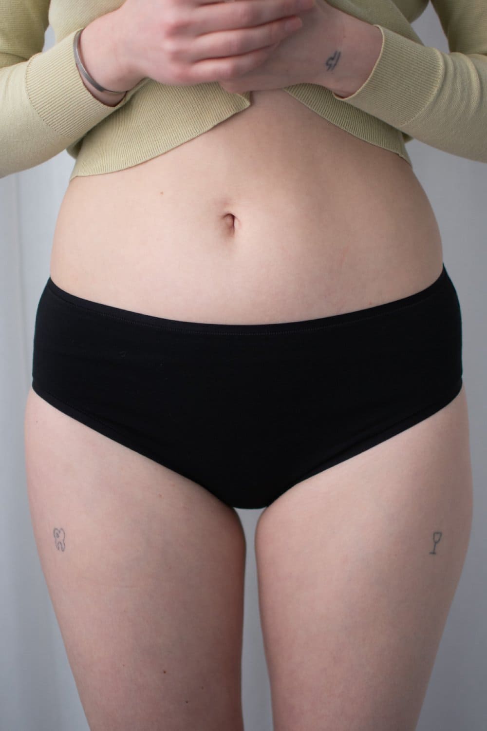 Natori bliss bare cotton hipster in black, front view on a model, close-up.