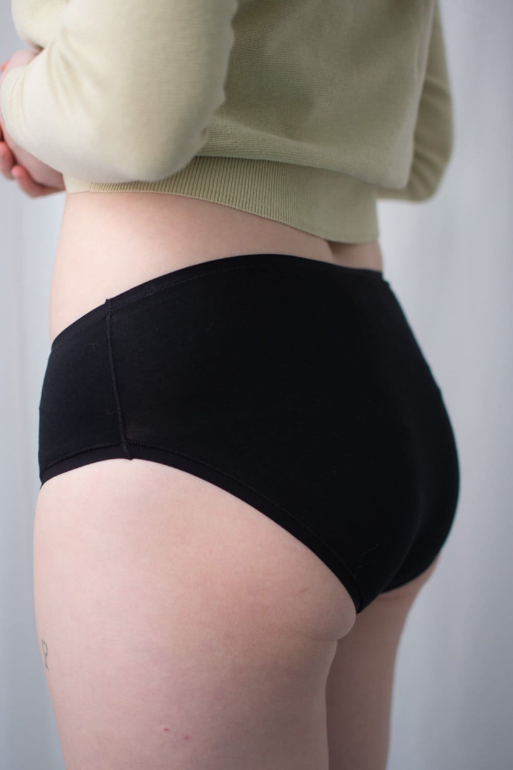 Natori bliss bare cotton hipster in black, side view on a model, close-up.