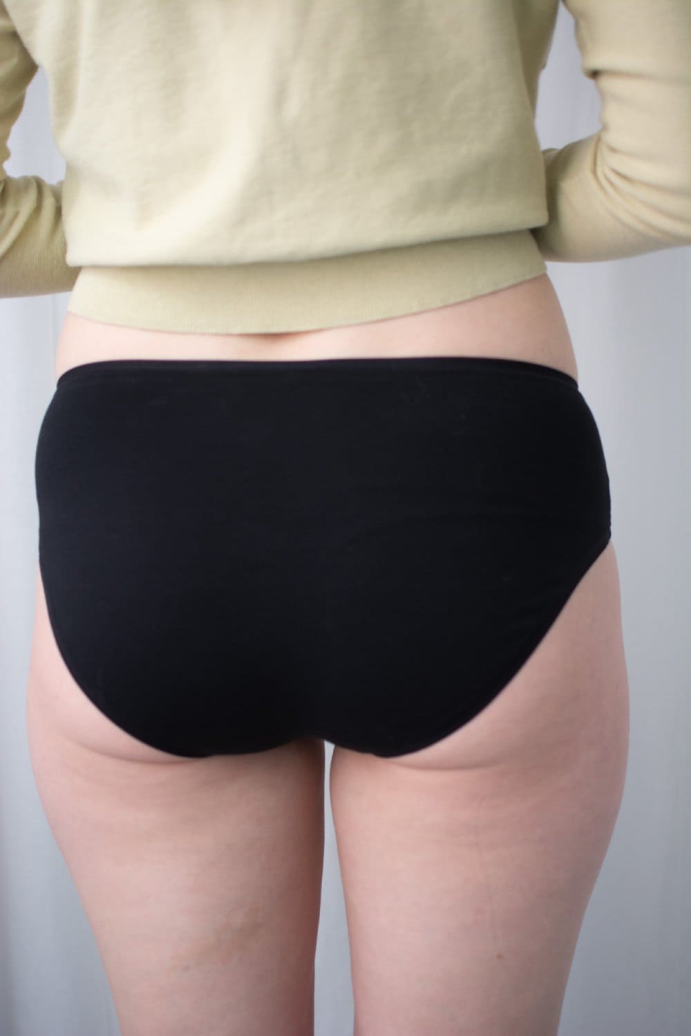 Natori bliss bare cotton hipster in black, back view on a model, close-up.