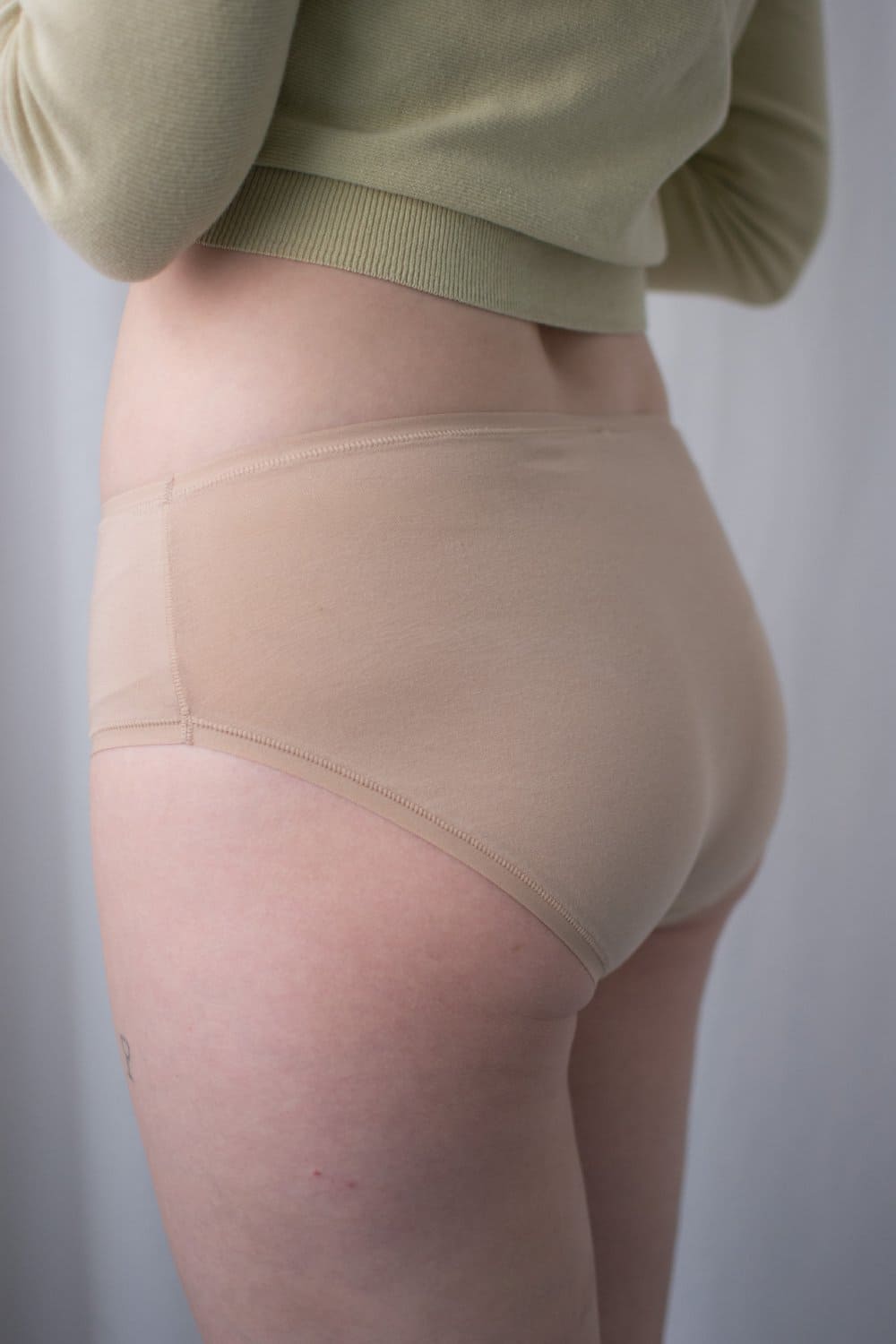 Natori bliss bare cotton hipster in cafe, side view on a model, close-up.