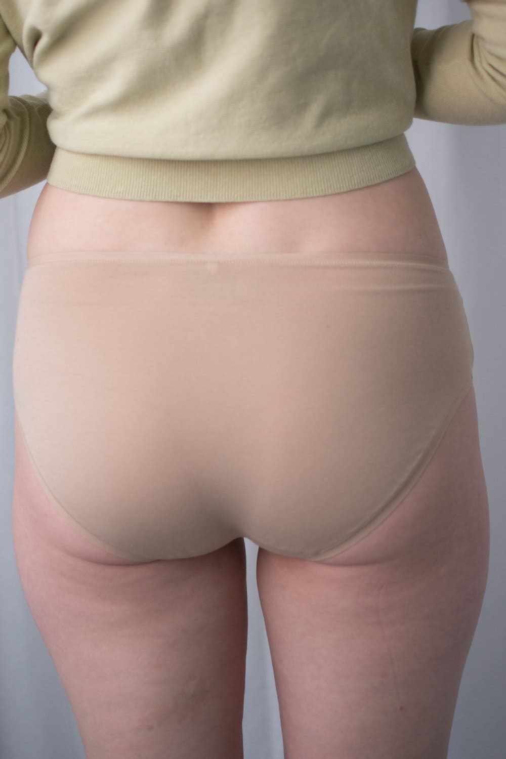 Natori bliss bare cotton hipster in cafe, back view on a model, close-up.