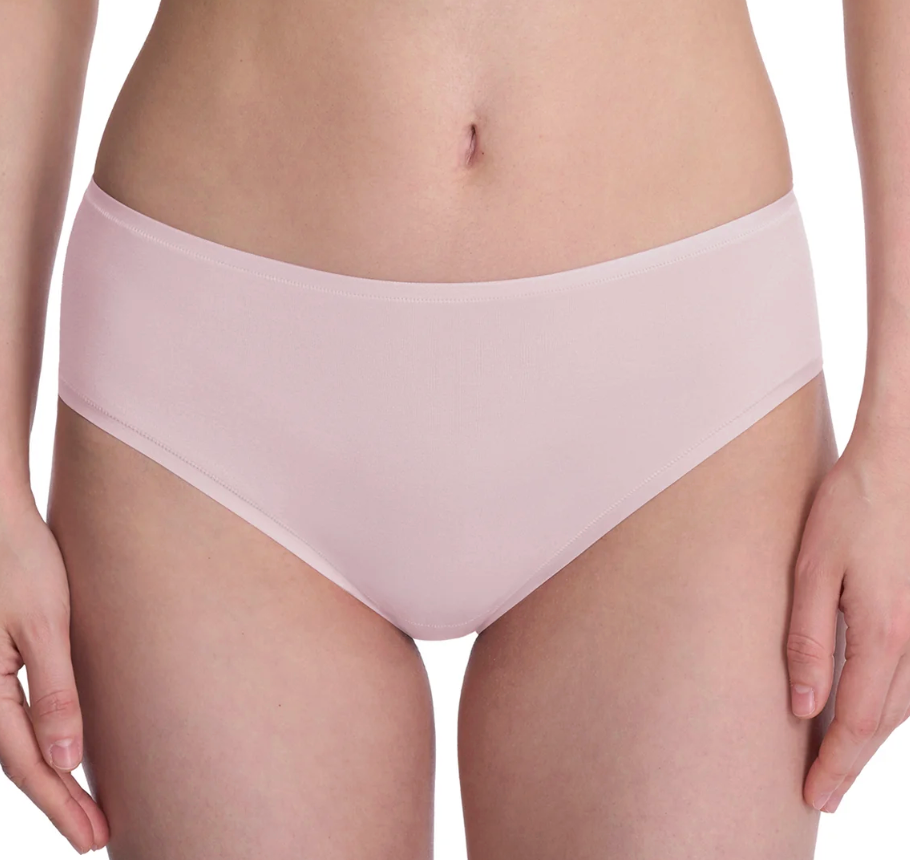 A close-up of a model wearing a light pink seamless underwear brief against a plain white background.