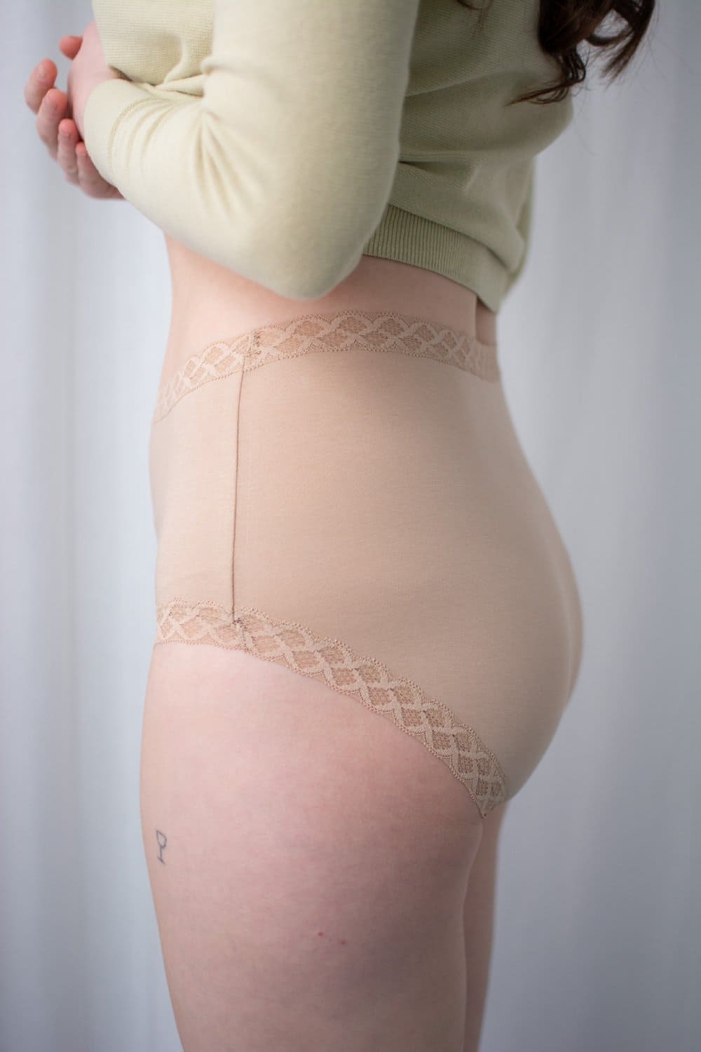 Natori Bliss full brief in cafe, side view on a model, close-up.