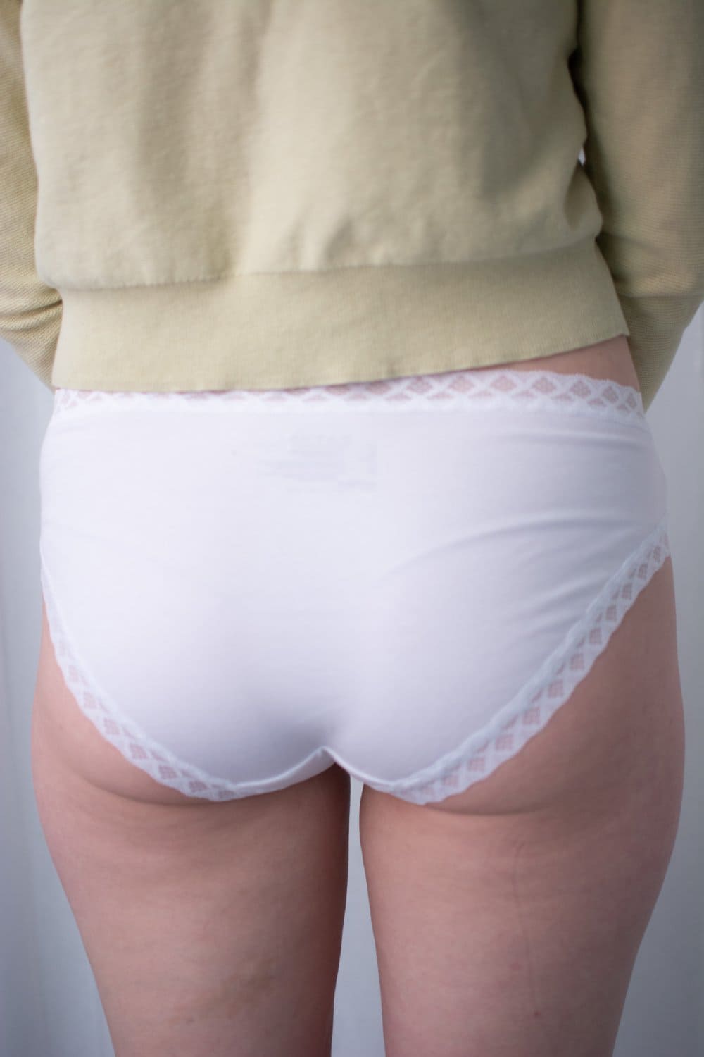 Natori Bliss girl brief in white, back view on a model, close-up.