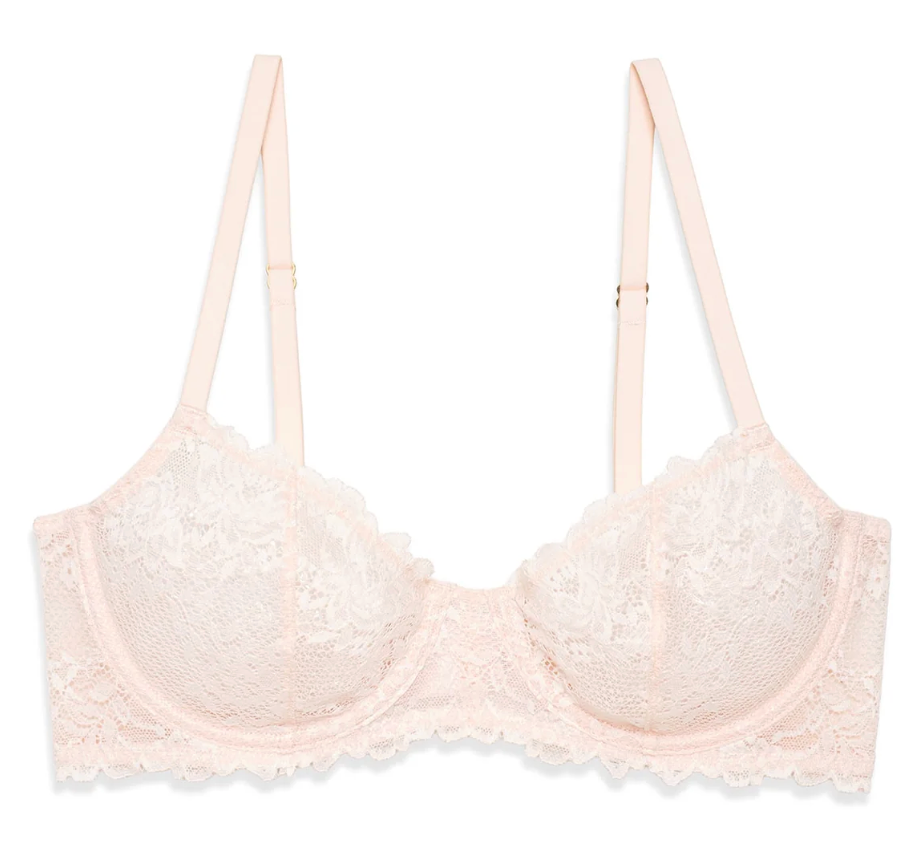 A pale blush pink lace underwire bra with adjustable shoulder straps and a scalloped lace trim, shown flat on a white background.