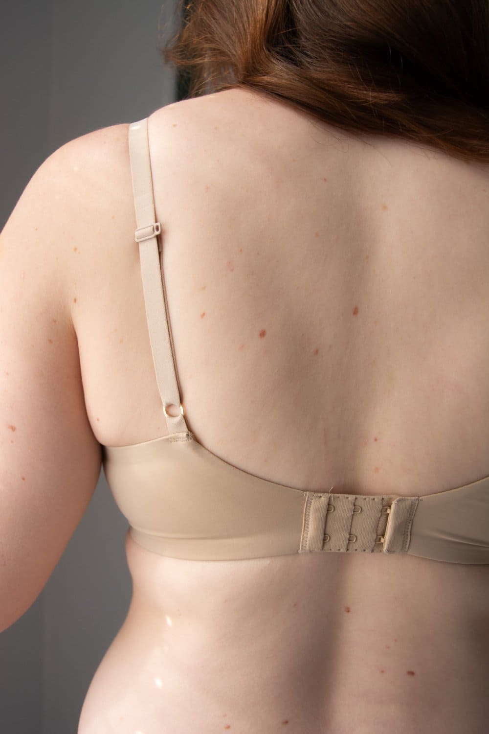 Natori Minimal Convertible Push-Up Bra in Cafe, back view on a model, close-up.