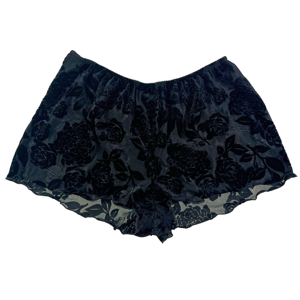 black floral shorts against a white background.