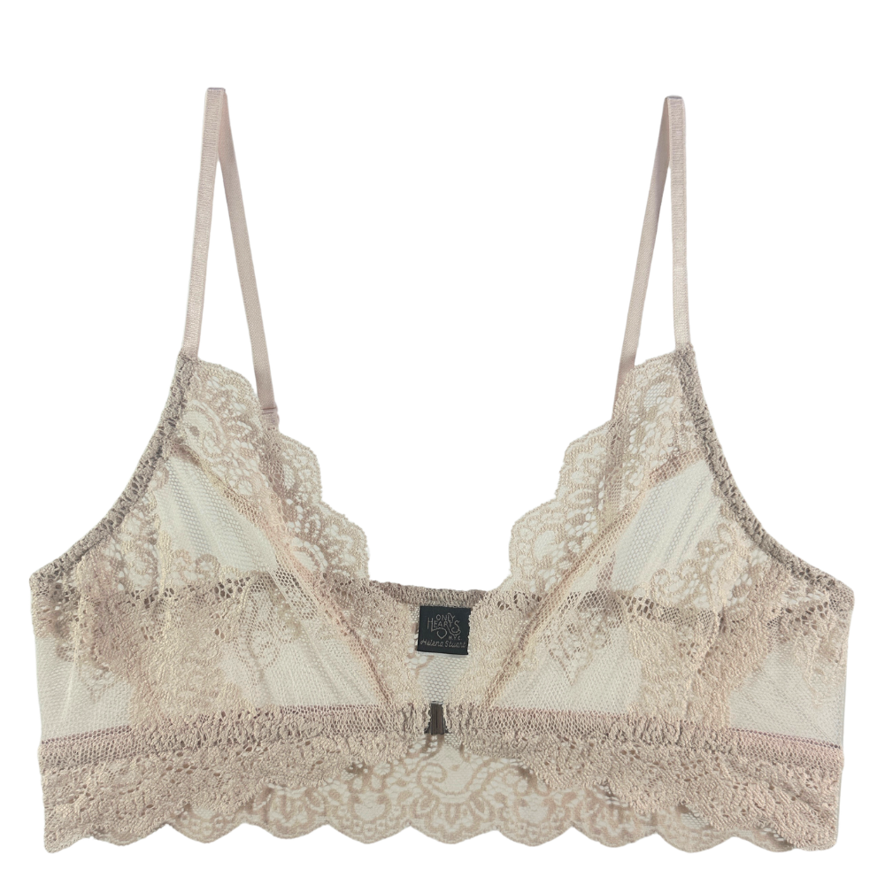 A beige lace bralette with thin straps, featuring scalloped edges, sheer mesh panels, and a small black brand label at the center front, shown against a plain white background.