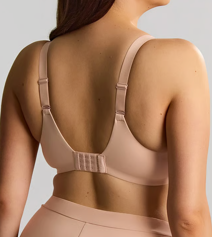 back of a person wearing beige bra against a white background.