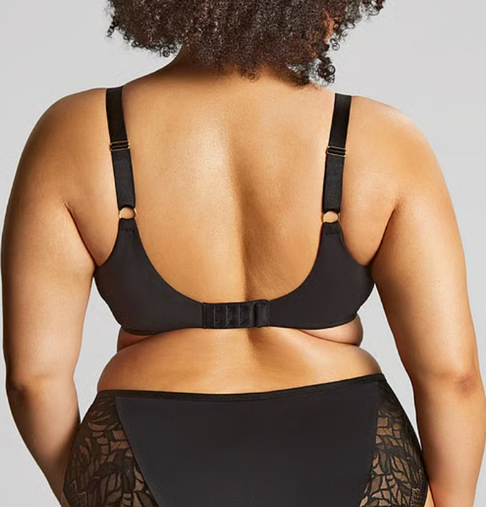 model from the back wearing black lace bra and underwear against a white background.