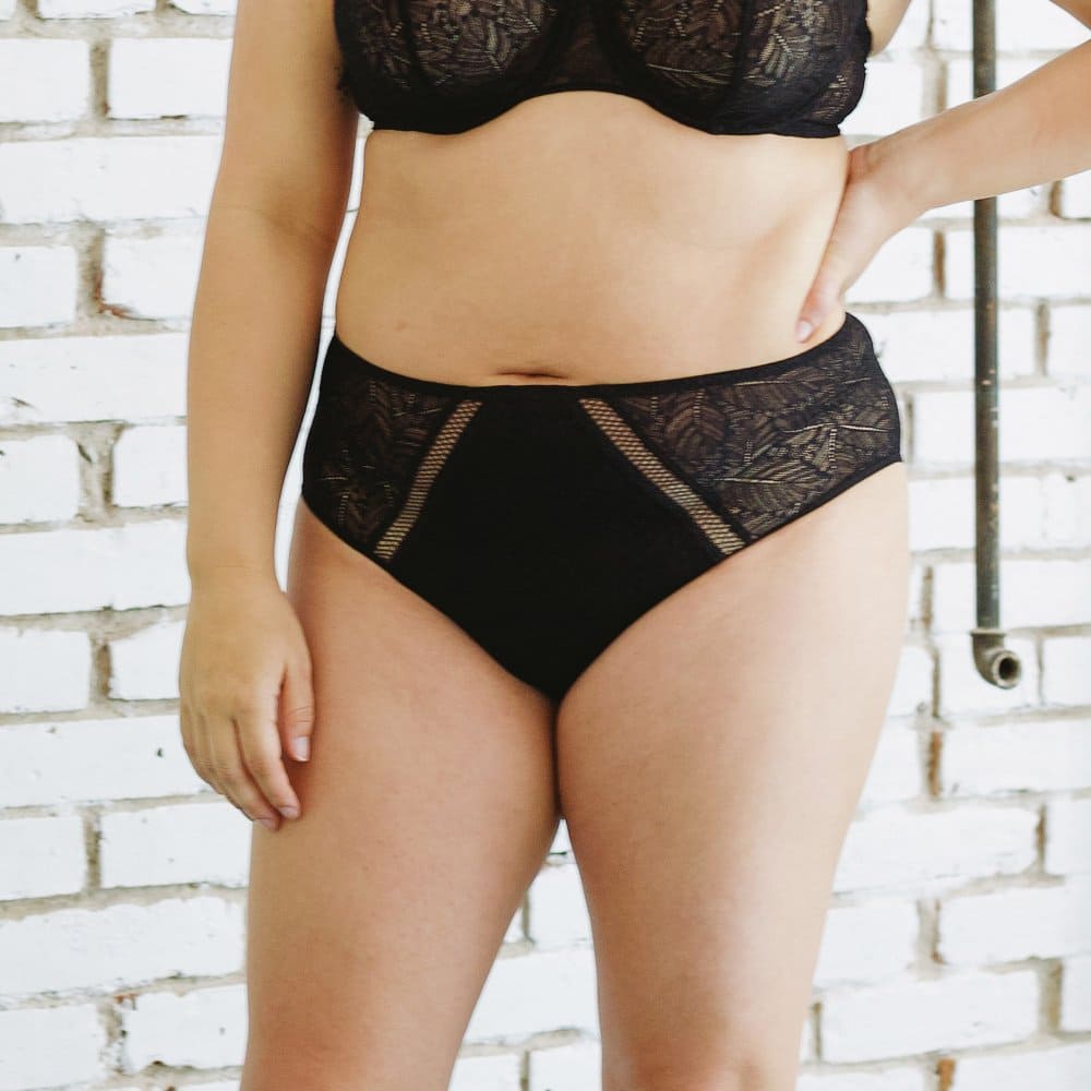 Simone Perele Comete culotte high-rise in black, front view on a model, close-up, smaller size product.