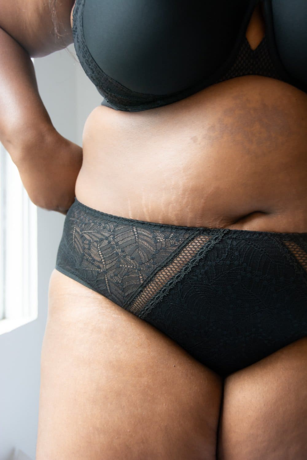 Simone Perele Comete culotte high-rise in black, front view on a model, close-up, large size product.