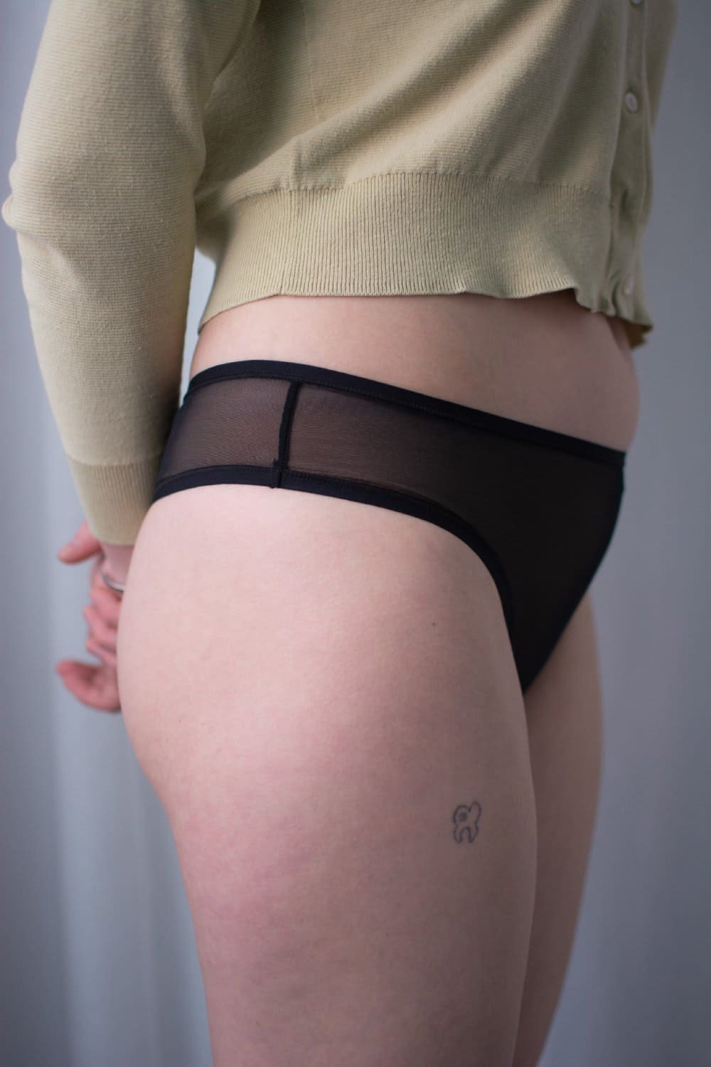 Skarlett blue spellbound nylon thong in black, side view on a model, close-up.